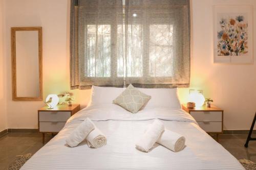 a bedroom with a large white bed with two pillows at Charming 2 BR in the Heart of Haifa by Sea N Rent in Haifa