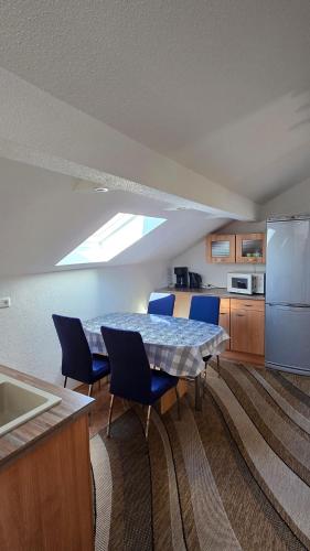a kitchen with a table with blue chairs and a refrigerator at Ferienwohnung Chiemsee in Chieming