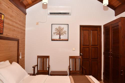 a bedroom with two beds and a tree picture on the wall at JKAB Lagoon Resort in Walauttu