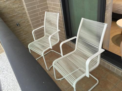 two white chairs sitting next to each other at Slowly inn in Hengchun