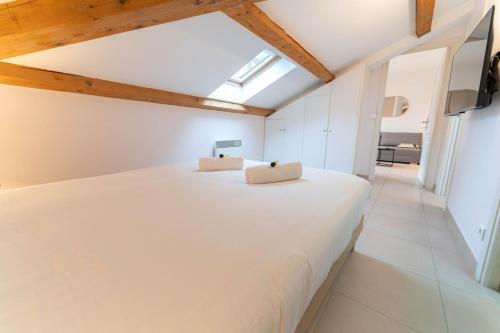 une chambre avec un lit blanc avec deux oreillers dessus dans l'établissement Cozy apartment - Monaco, à Beausoleil