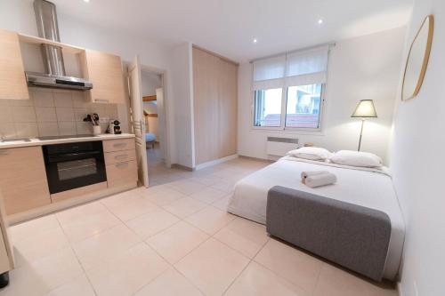une grande chambre avec un lit et une cuisine dans l'établissement Cozy apartment - Monaco, à Beausoleil