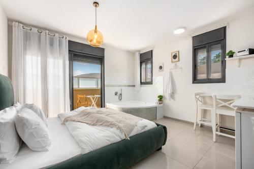 a bedroom with a large bed and a bathroom at Hadas Villa Spa Yavne'el with Mamad by Sea N' Rent in Yavneʼel