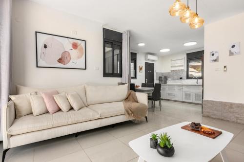 a living room with a couch and a table at Hadas Villa Spa Yavne'el with Mamad by Sea N' Rent in Yavneʼel