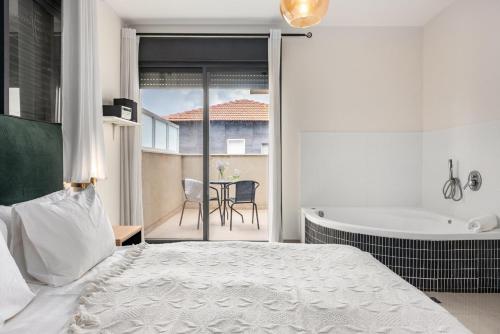 a bedroom with a bed and a tub and a table at Hadas Villa Spa Yavne'el with Mamad by Sea N' Rent in Yavneʼel