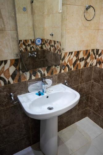 a bathroom with a white sink and a mirror at شقق أهلين خمسة للشقق المخدومة in Riyadh