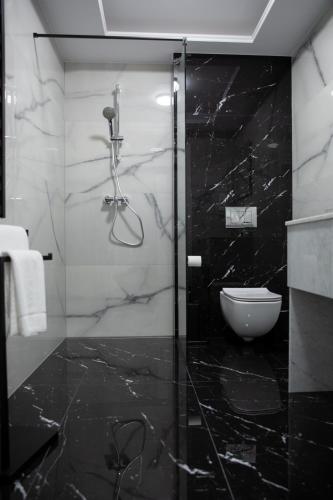 a black and white bathroom with a glass shower at Wisteria Hotel in Laskowiec