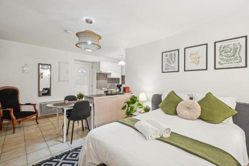 une chambre avec un grand lit et une cuisine dans l'établissement Studio garden and serenity, near Eurexpo and GroupamaStadium, à Saint-Priest