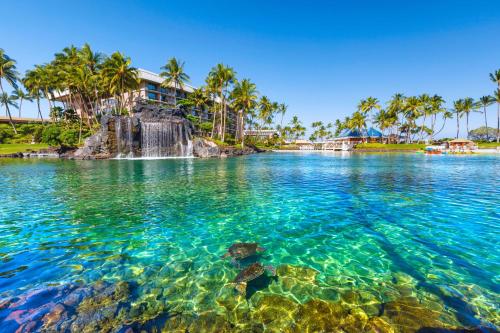 a view of the water at a resort with palm trees at ALOHA SHORES Spacious Ainamalu 4BR Home with Mountain and Ocean View in Waikoloa