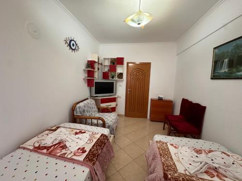 a small room with two beds and a television at Anita Apartment in Përmet