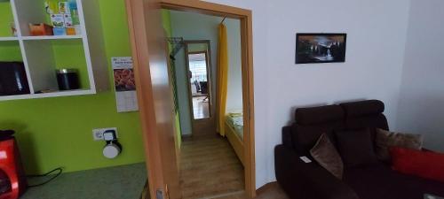 a living room with a couch and a mirror at Ferienwohnung in Spreewaldnähe in Kolkwitz