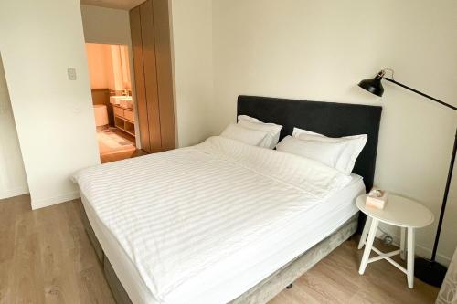 a white bed with a black headboard in a bedroom at Docklands Luxury Comfort Apartment in Melbourne