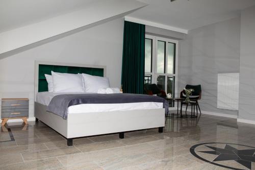 a bedroom with a bed and a table and a chair at Wisteria Hotel in Laskowiec