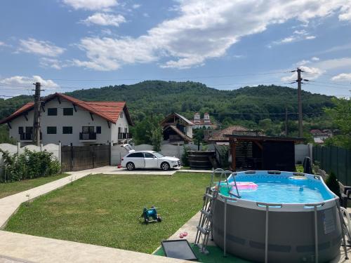 a backyard with a swimming pool and a car parked at Cabana EvAy in Ocnele Mari