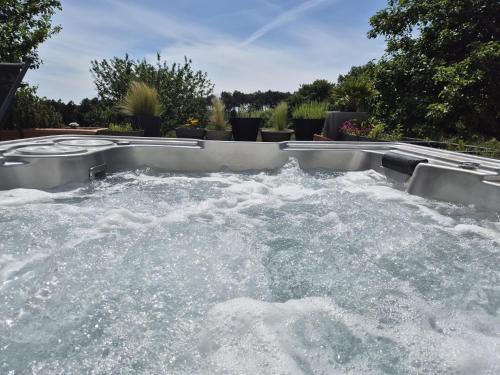 a hot tub filled with water in a backyard at Ty Nehue - Maison avec jacuzzi in Crach