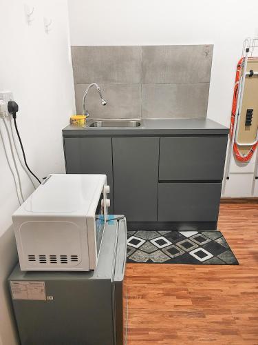 a kitchen with a sink and a microwave at K Avenue Small Studio Homestay in Donggongon