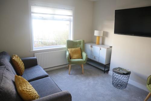 a living room with a couch and a chair and a television at 3 Bed home, Stranmillis, Queens Quarter in Belfast