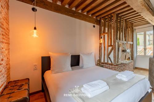 une chambre avec un lit avec des draps blancs et une fenêtre dans l'établissement Le Spa de Lou Hot Tub Sauna & Private Patio 2 Guests, à Honfleur