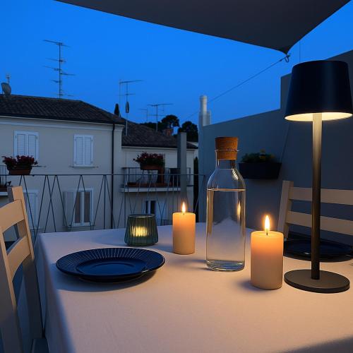 a table with two candles and a bottle on a table at Terra Cielo alloggio di Porta Santi in Cesena