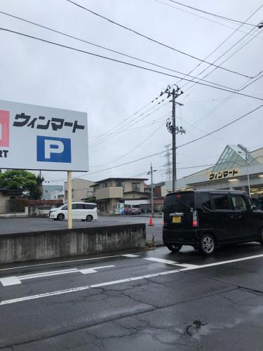 a black van parked on a street with a parking sign at 日本家庭風一軒家 いずみ in Sendai