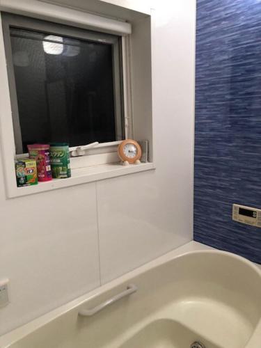 a bathroom with a bath tub and a window at 日本家庭風一軒家 いずみ in Sendai
