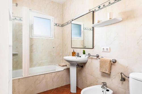 a bathroom with a sink and a toilet and a mirror at Villa Toymi by Villa Plus in Cala Blanca