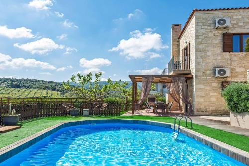 a swimming pool in the backyard of a house at Villa Erato Klio in Kiriánna