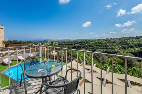 a balcony with a table and chairs and a pool at Villa Erato Klio in Kiriánna