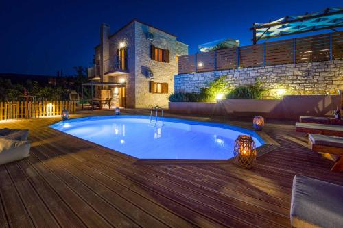 a swimming pool in front of a house at night at Villa Erato Klio in Kiriánna