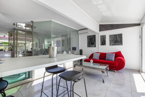 un salon avec un canapé rouge et une table dans l'établissement Village Naturiste R4N - La Villa Shimmer Luxe, au Cap d'Agde