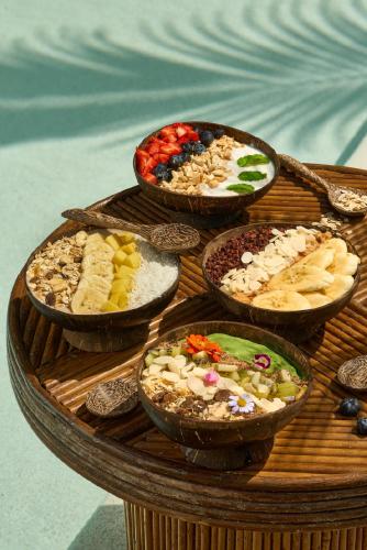 a table topped with bowls of different types of food at Café del Mar Phuket - Suite & Penthouse in Kamala Beach