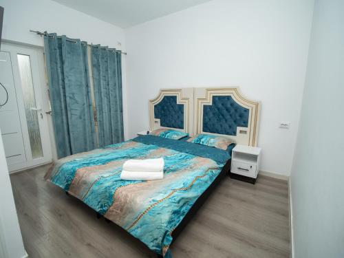 a bedroom with a large bed with a blue bedspread at Central house in Iaşi