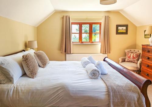 a bedroom with a large white bed with towels on it at Ramblers Rest in Yarpole