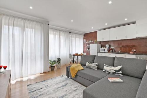 a living room with a gray couch and a kitchen at Apartamento Ponte D Luís in Vila Nova de Gaia