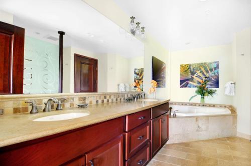 une salle de bain avec deux lavabos et un grand miroir dans l'établissement Waipouli Beach Resort Luxury Garden Ground Floor! AC Pool, à Kapaa