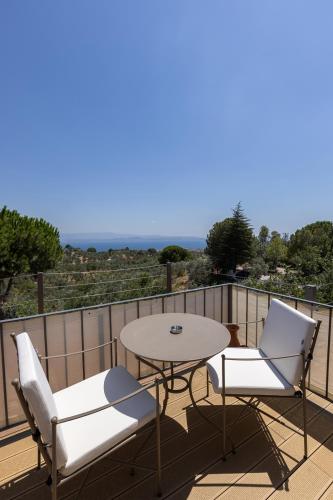 a patio with a table and chairs on a balcony at Ida Trio in Edremit