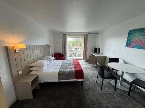 a hotel room with a bed and a table at Grand studio sur le golf de Chiberta in Anglet