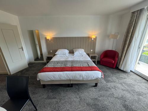 une chambre d'hôtel avec un lit et une chaise rouge dans l'établissement Grand studio sur le golf de Chiberta, à Anglet