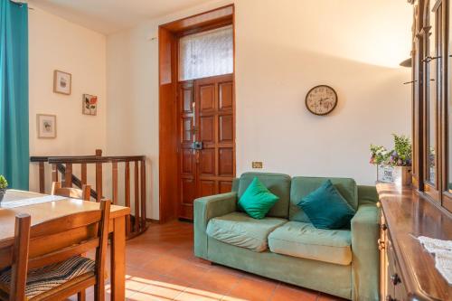 a living room with a couch and a clock on the wall at Traveler's Retreat in Lecco in Lecco