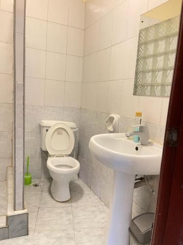 a bathroom with a toilet and a sink at Nyali Sunrise Apartment in Nyali