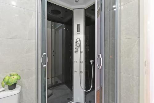 une douche avec une porte en verre dans une salle de bain dans l'établissement Apartamento Ponte D Luís, à Vila Nova de Gaia