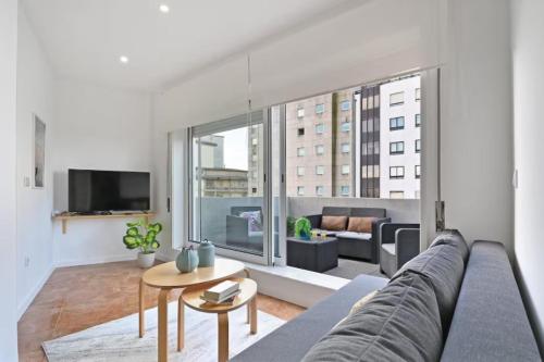 a living room with a couch and a large window at Apartamento Ponte D Luís in Vila Nova de Gaia