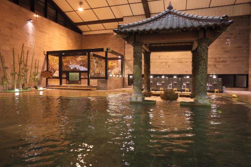 a pool of water with a pavilion in a building at Kagoshima Sunamushionsen Ibusuki Hakusuikan in Ibusuki