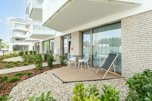 a patio with two chairs and a table at Sarbinove City Apartments in Sarbinowo