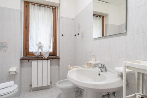 a white bathroom with a sink and a toilet at Lecco Incanto in Lecco