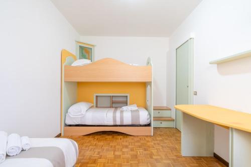 a small room with two beds and a desk at Lecco Incanto in Lecco