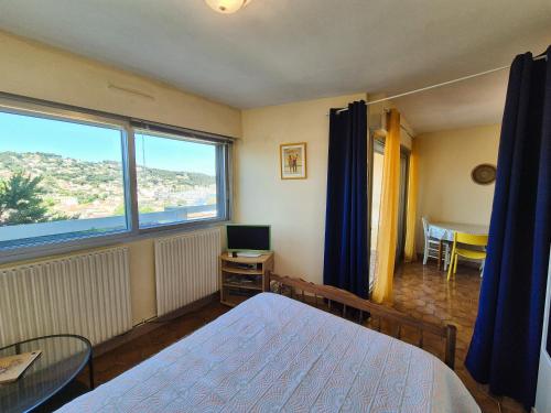 une chambre avec un lit, une table et une fenêtre dans l'établissement Vue mer, plage à pied – Résidence avec piscine tennis, à Saint-Mandrier-sur-Mer