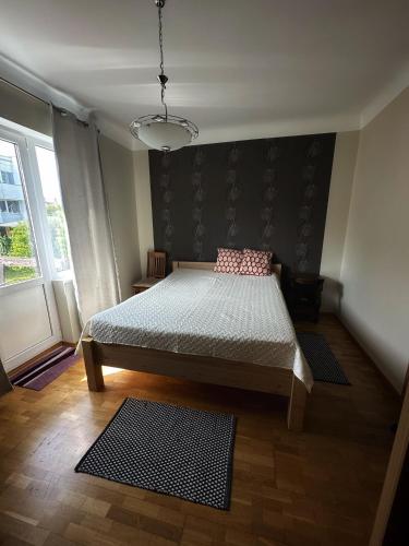 a bedroom with a bed and a large window at Janno apartment in Pärnu