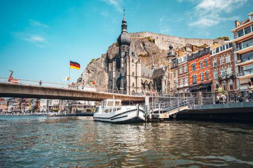 a boat docked next to a bridge on a river at Pénichettes Dinant Evasion in Dinant