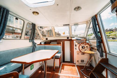 a boat with a table and a steering wheel at Pénichettes Dinant Evasion in Dinant